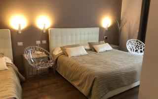 Modernes Zimmer mit Doppelbetten und transparenten Stühlen.
