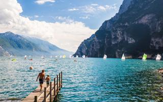 Lake with sailboats and mountains in the background.