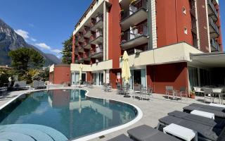Piscina all'aperto con vista montagna e hotel moderno.