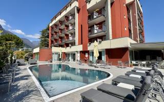 Hotel moderno con piscina e vista montagna.