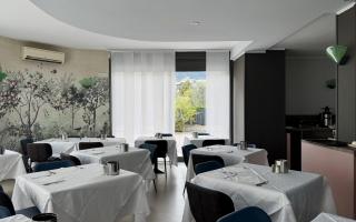 Elegant restaurant with floral decorations and set tables.