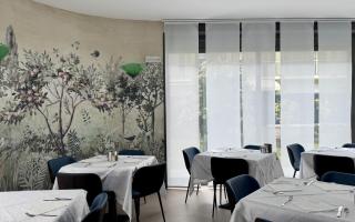 Elegantes Esszimmer mit botanischem Wandbild und gedeckten Tischen.