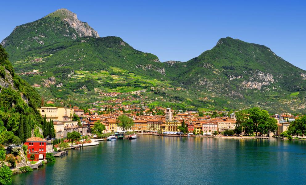 Città lacustre con montagne verdi e cielo blu.