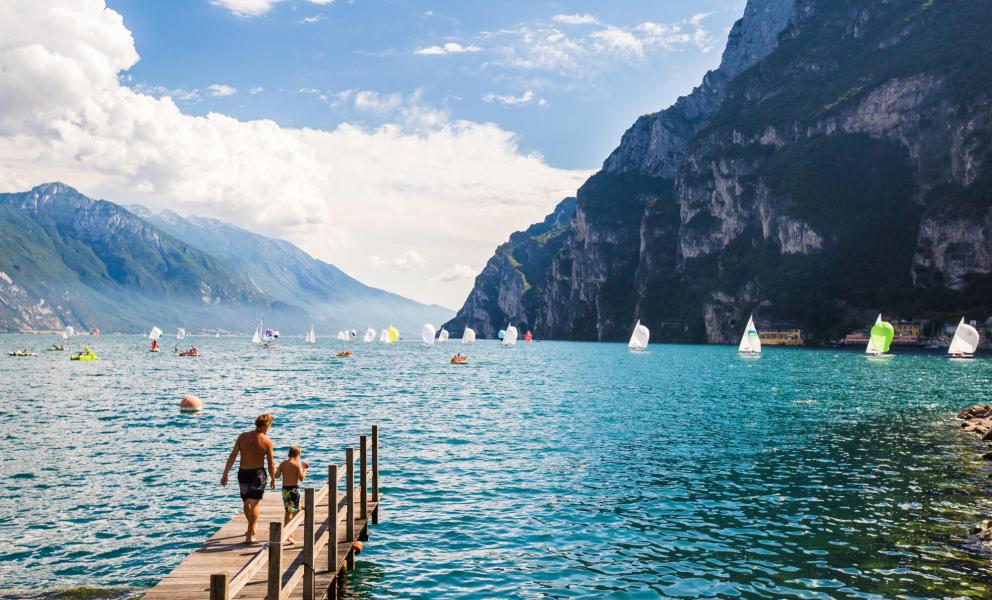 Lake with sailboats and mountains in the background.