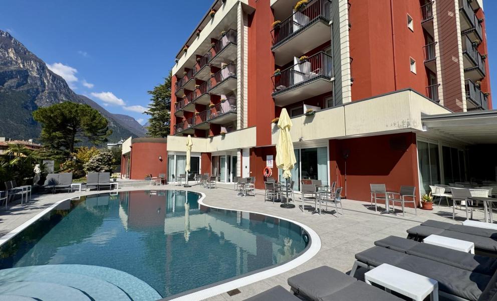 Piscina all'aperto con vista montagna e hotel moderno.