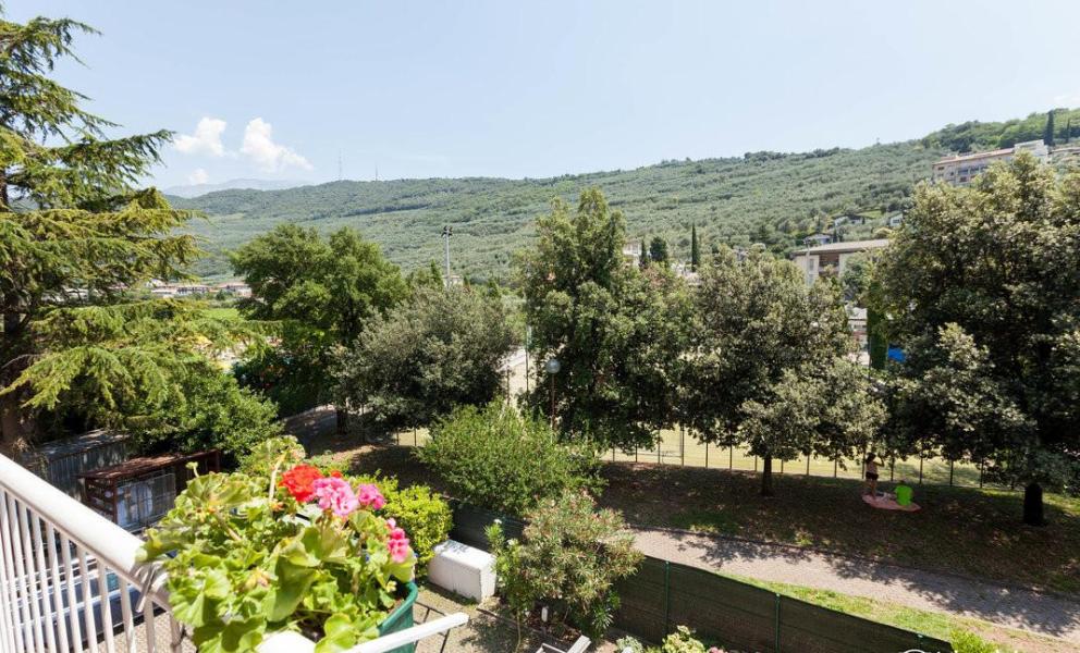 Vista serena su colline verdi e fiori colorati dal balcone.