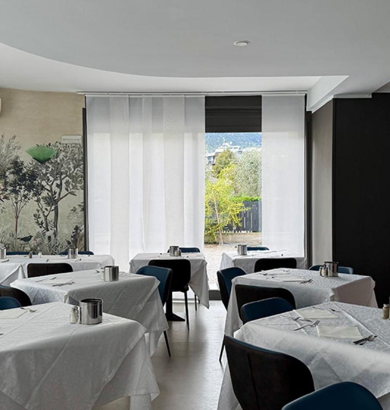 Elegant restaurant with set tables, relaxing atmosphere, and natural decorations.