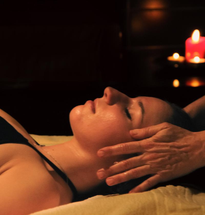 Massaggio rilassante con candele accese in un ambiente tranquillo.
