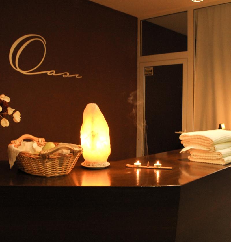 Reception di una spa con luci soffuse e decorazioni accoglienti.